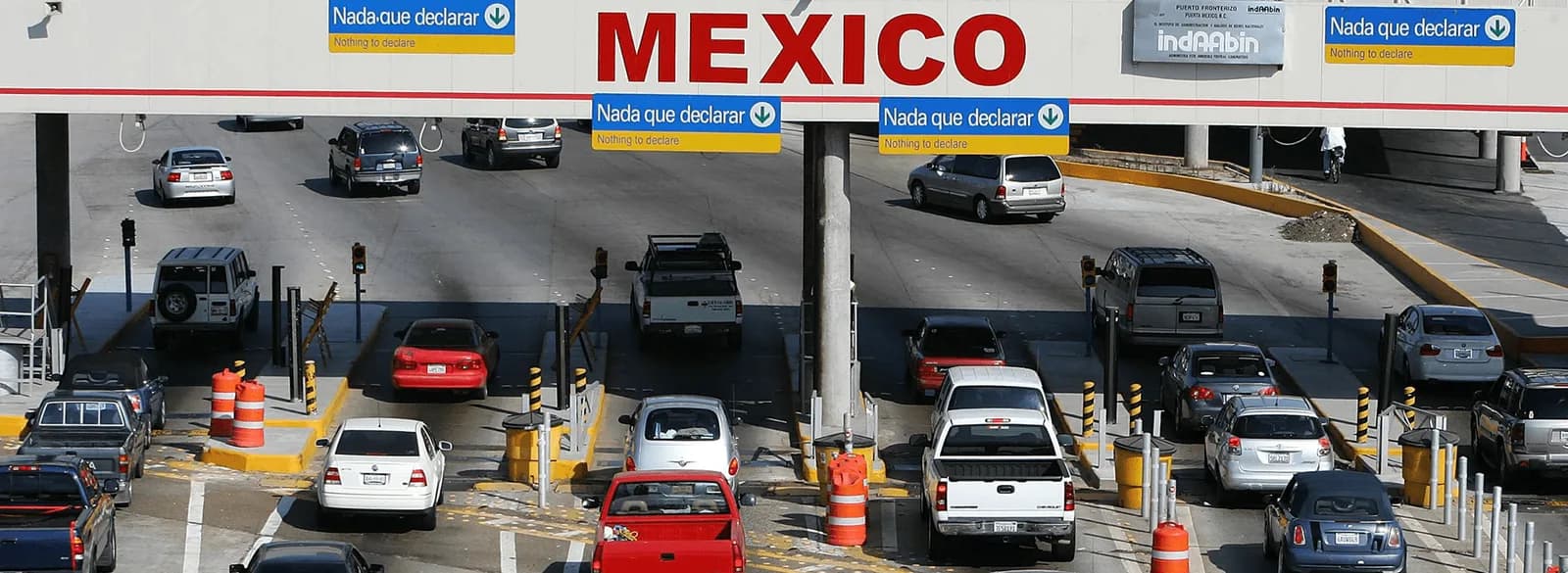 Mexican border inspection plaza with Nada que declarar lanes full of vehicles — best time to cross the border into Mexico